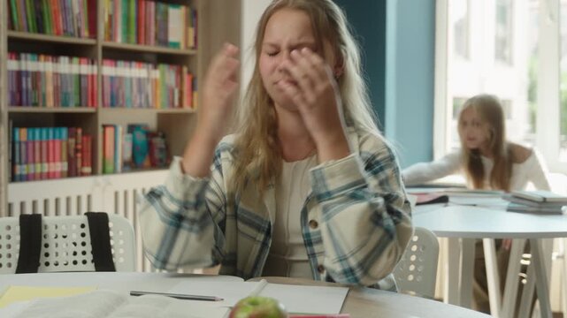 Stressed angry Caucasian teen little girl child struggling writing exam indoors classroom frustrated student schoolgirl kid solving difficult task exhausted pupil problem education studying burnout