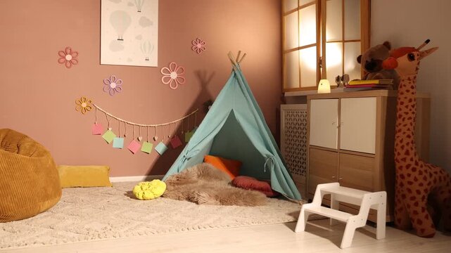 Colorful paper notes hanging on brown wall near toy wigwam and pouf in stylish children's room, camera moving left. Interior design