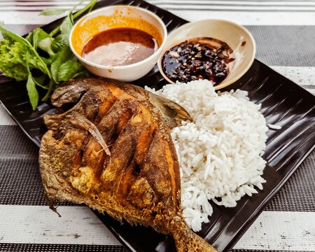 Bawal Goreng or fried gurame with rice and side dish.