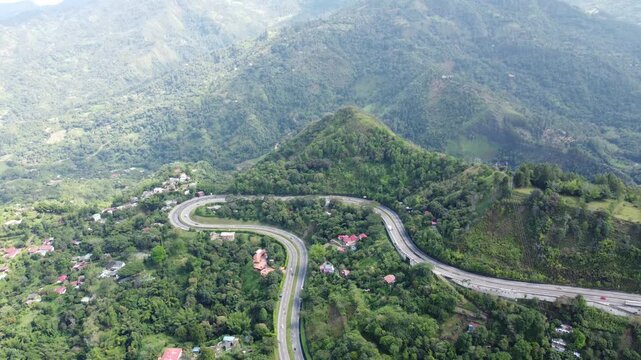 Aerial view from drone approaching curve road in la vega town in cundinamarca Colombia, Mountains arround blue sky