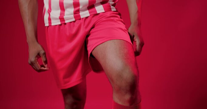 Cam rising revealing African American man balancing soccer ball, posing for portrait in studio