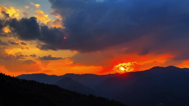 A serene and meditative view of a round red sun slowly dipping below the layered mountain ranges during a golden twilight in rural China.