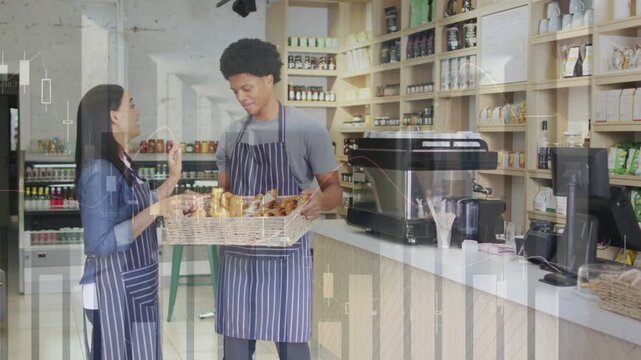 Cafe barista woman pointing at pastry, coworker holding basket steadying and inspecting for display