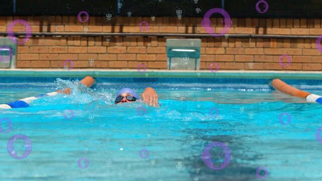 Male swimmer doing backstroke from wall, splashing as purple circles overlaying lane for training