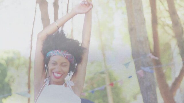 Woman raising arms, swaying and tilting head, touching hair as man smiling, watching, celebrating