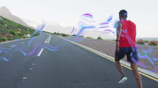 Male runner starting run on winding road, pushing off, motion trail flowing around him for fitness