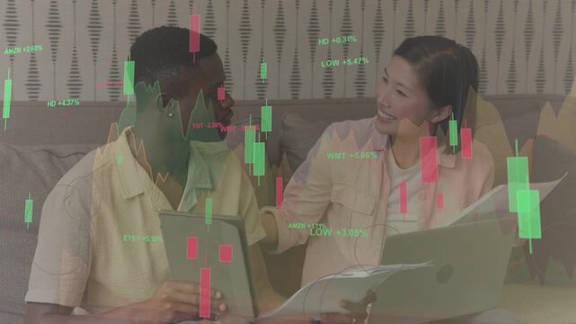 Man and woman reaching laptop while exchanging papers, analyzing stocks with translucent charts