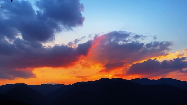Stunning timelapse of vibrant orange sunrise light contrasting with a deep blue flowing sea of clouds in Southwest China.