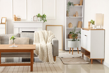 Obraz premium Interior of light living room with sofa, table and plants