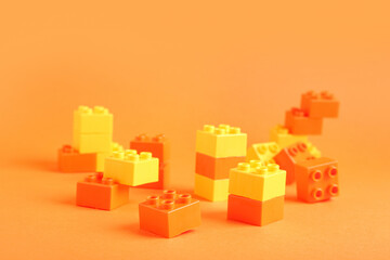 Naklejka premium Colorful plastic building blocks on orange background