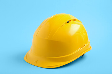 Fototapeta premium Yellow hardhat on blue background