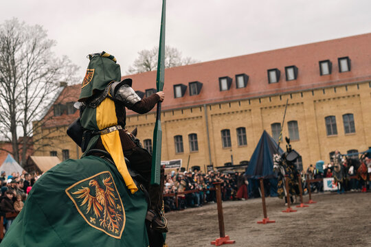 Rear view of mounted knight approaching jousting lane at medieval event in Berlin