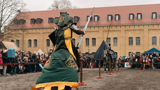 Rear view of mounted knight approaching jousting lane at medieval event in Berlin
