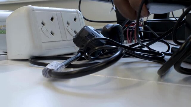 close up view of unplugging electronic devices from electricity socket power saving concept low angle locked off.