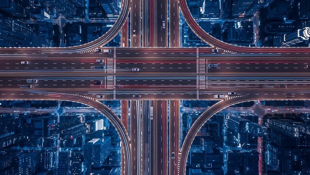 Aerial view of a complex highway interchange with multiple roads merging at night