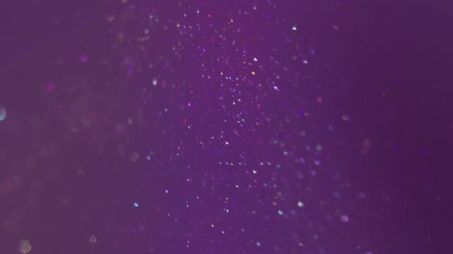 Shimmering mix. Paint blur water. Purple violet color emulsion shiny stream. Art defocused abstract liquid gleam particles background.
