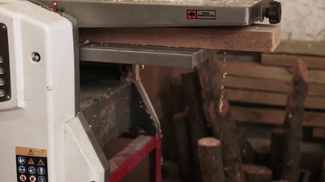 Wood workshop. Carpentry equipment. Thickness planer electrical professional machine processing plank. Powerful timber industry tool.