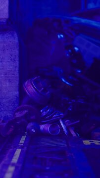 A group of worn items rests on the ground near a rough wall in a low light setting. The scene shows parts lying together suggesting neglect or abandonment.