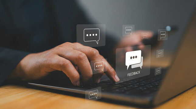 A person types on a laptop keyboard with floating digital feedback speech bubble icons