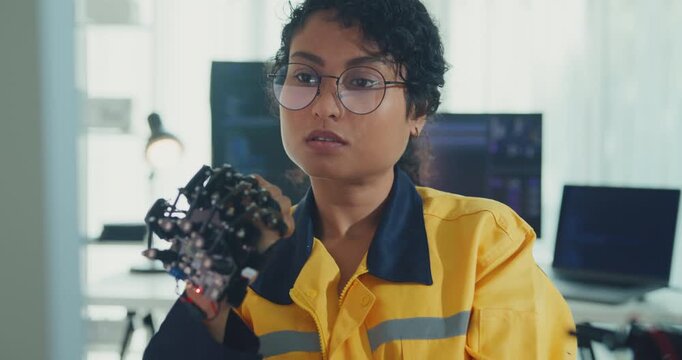 Young Black female engineer coding AI robot arm in modern laboratory. Robotics, artificial intelligence, technology, stem, future, innovation, diversity, automation, machine learning concept.