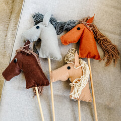 Handmade felt hobby horse stick toys with yarn mane on sofa © biancalief