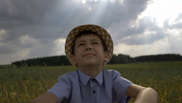 dreamer boy in the hat looks at the beautiful sky, have fun and enjoy