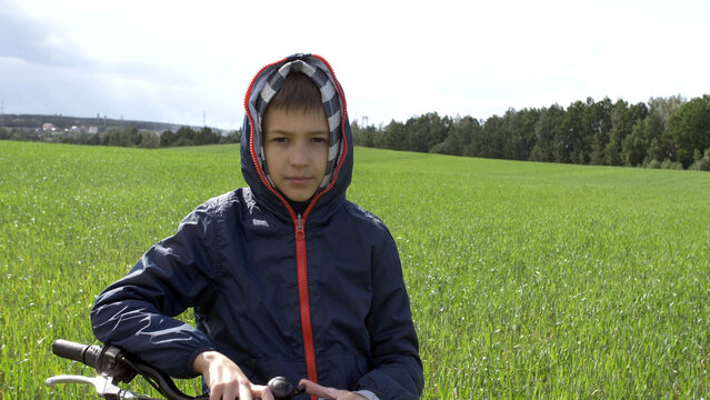 portrait of a biker boy standing in the field and looking at the camera, have fun and enjoy