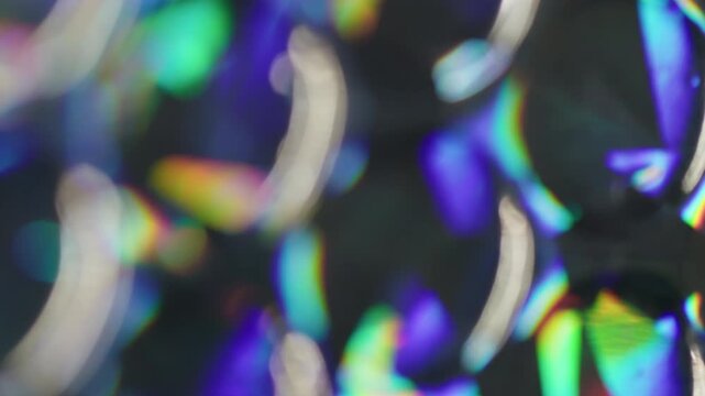 Blur crystal bubbles. Rainbow light. Orange blue green colorful round radiant gleam leak on abstract illuminated uneven dark black background.
