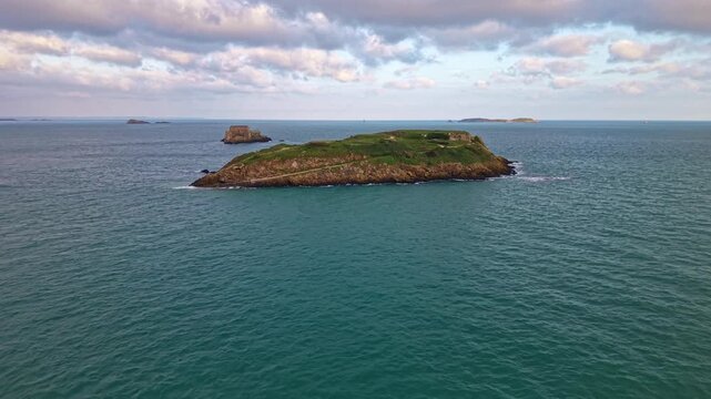Approaching drone fly to rocky tidal island of Grand Bé and Fort du petit Bé in background at La Manche, Saint-Malo, Brittany, France