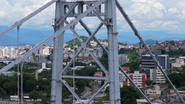 Herc&iacute;lio Luz Bridge in Florian&oacute;polis Santa Catarina Brazil showing steel tower structure and truss detail over Ba&iacute;a Norte with urban backdrop in Atlantic Ocean setting, drone pullback