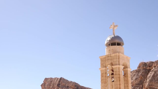 View of the bell tower and stone architecture of the Monastery in Ma'aloula, Syria. Historic Christian site nestled under the dramatic mountain cliffs