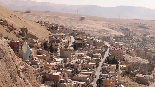 High-angle view of the narrow valley and historic houses of Ma'aloula, Syria. Famous Christian pilgrimage site built into the rugged limestone mountains