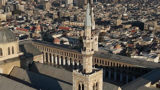 Close-up aerial drone shot of the iconic minaret and courtyard of the Great Umayyad Mosque in Damascus