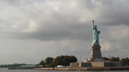 Fototapeta premium Statue of Liberty on Liberty Island, New York, United States. Cooper monument, symbol of democracy and patriotism near Manhattan, NYC USA. View from ferry boat, tourist cruise.