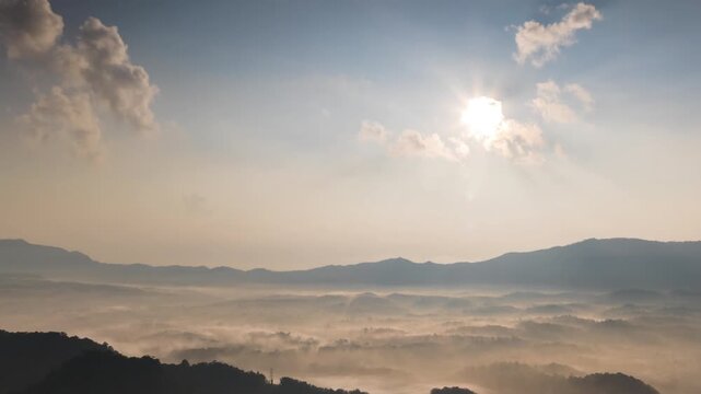 Hyperlapse by dorne Spectacular aerial view of a sea of mist covering mountain ranges under a bright mornig sun. Captures peaceful nature, morning fog, and scenic horizons at sunrise.