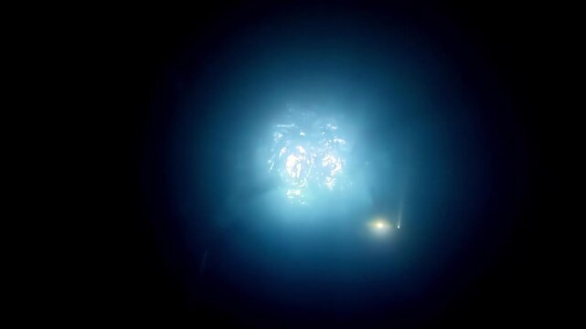 Mysterious cinematic underwater scene showcasing a glowing ethereal light source deep beneath the dark ocean surface during a cold winter night captured from a dramatic low wide camera angle view