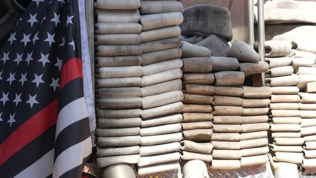 Red thin line black american flag on firefighter truck. Hose of firetruck and fire fighters symbol in New York, United States. 911 remembrance, fire department engine vehicle. September 11 Patriot Day