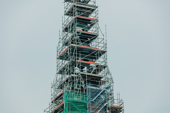 City hall tower under renovation with construction scaffolding, reconstruction work, historic building