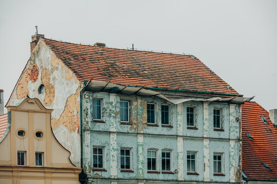 Eastern Europe 19th century houses, crumbling facade, cracked plaster and paint, neglected old town center.
