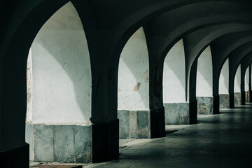 Naklejka premium Nineteenth-century arcade under houses for pedestrian passage, shadow, old town, Europe