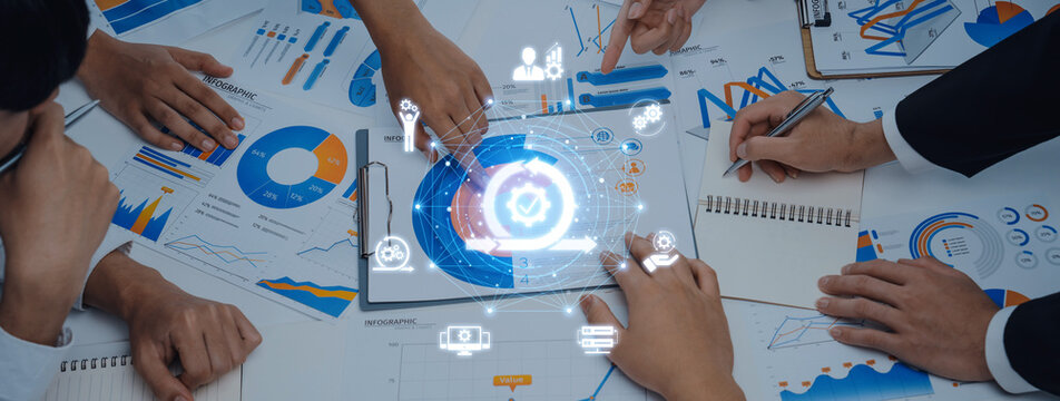 A dynamic business meeting scene showcasing hands working on data analysis, graphic charts, and digital icons, representing collaboration and innovative ideas. Trope