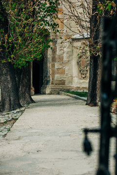 19th century European Catholic church inner courtyard with grass, stone, facade, Poland