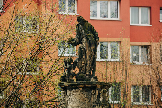 Statue of St. Jude Thaddeus with 1990s Polish apartment blocks behind near church