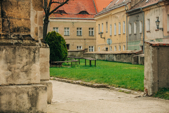 19th century European Catholic church inner courtyard with grass, stone, facade, Poland