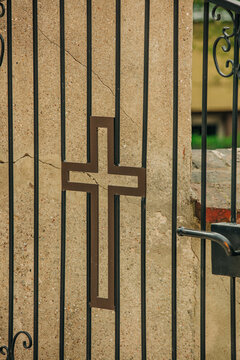 Metal cross on gate at entrance to Catholic church, Poland, Europe.