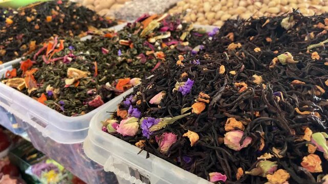 Various loose leaf tea blends with dried flowers displayed at a market