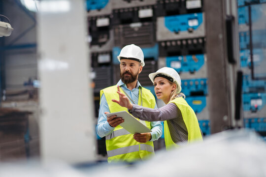 Industrial team evaluate the production process in high tech manufacturing plant.