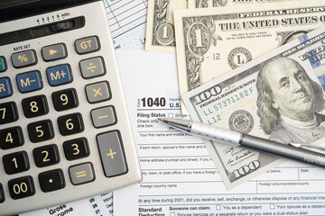 Obraz premium Tax form 1040 U.S. Individual Income Tax Return with dollar banknotes money.