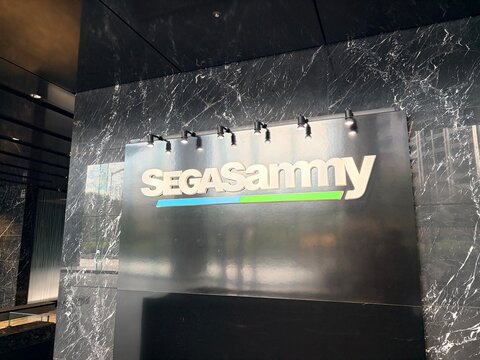 Sega Sammy Holdings corporate logo signage mounted on black marble wall on the ground floor of Osaki Garden Tower in Shinagawa - Tokyo, Japan, January 23, 2026