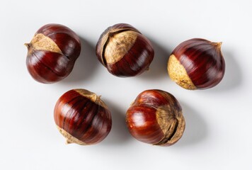 Obraz premium Five Fresh Shiny Brown Chestnuts Arranged Artfully on a Clean White Background Surface Top View